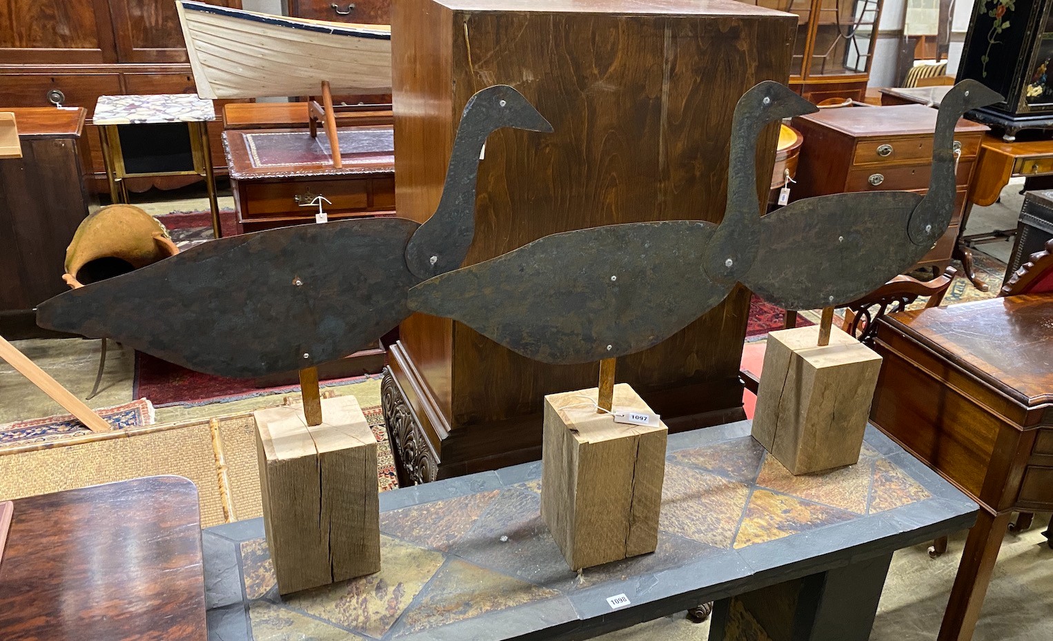 A set of three primitive style copper wildfowlers silhouette decoy models of geese with articulated necks on oak bases, height 75cm